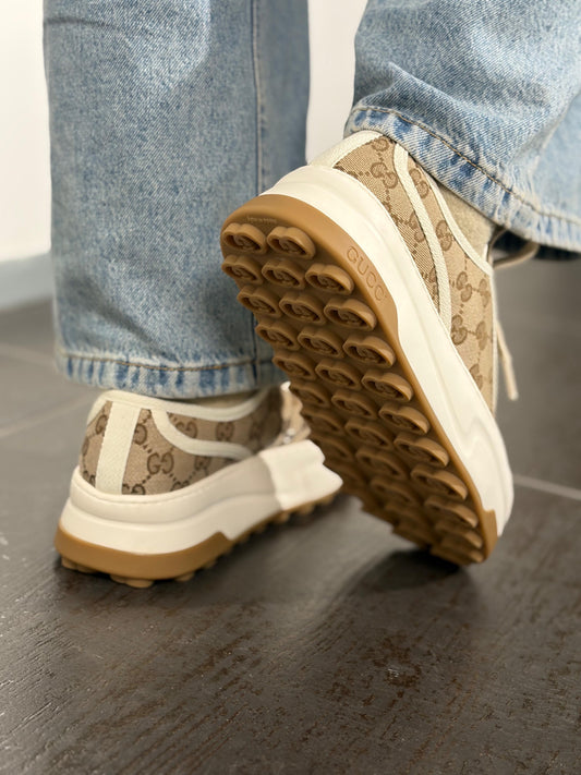 Ragazza che indossa delle scarpe Gucci realizzate in tela monogram GG con profili in tela bianca e para color crema, usate, originali, second hand, in condizioni eccellenti.