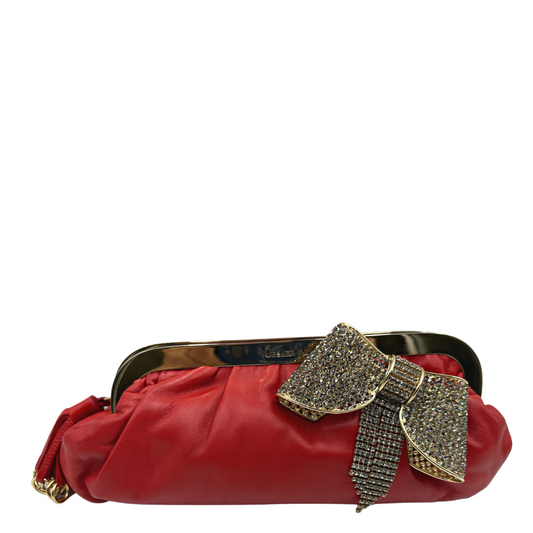 Pochette Paciotti in pelle color rosso aranciato con parti metalliche dorate; impreziosita con un maxi fiocco con strass e nappina con anelli. Completa di dustbag.