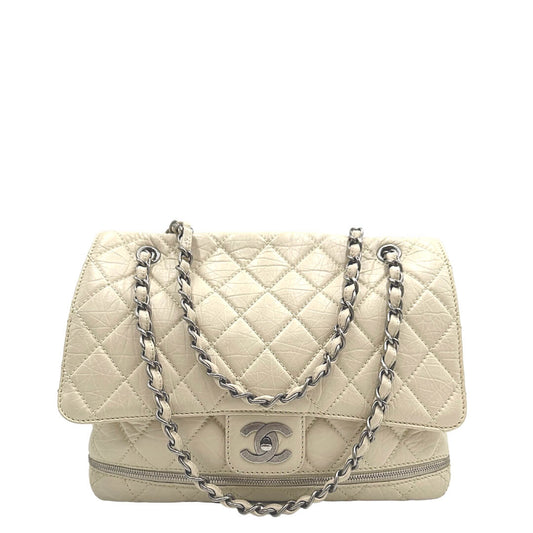 Front di una borsa Chanel in pelle matelassè color bianco crema rifinita con parti metalliche argentate; munita di una tracolla in pelle e catena intrecciata. Completa di dustbag e card d'autenticità.