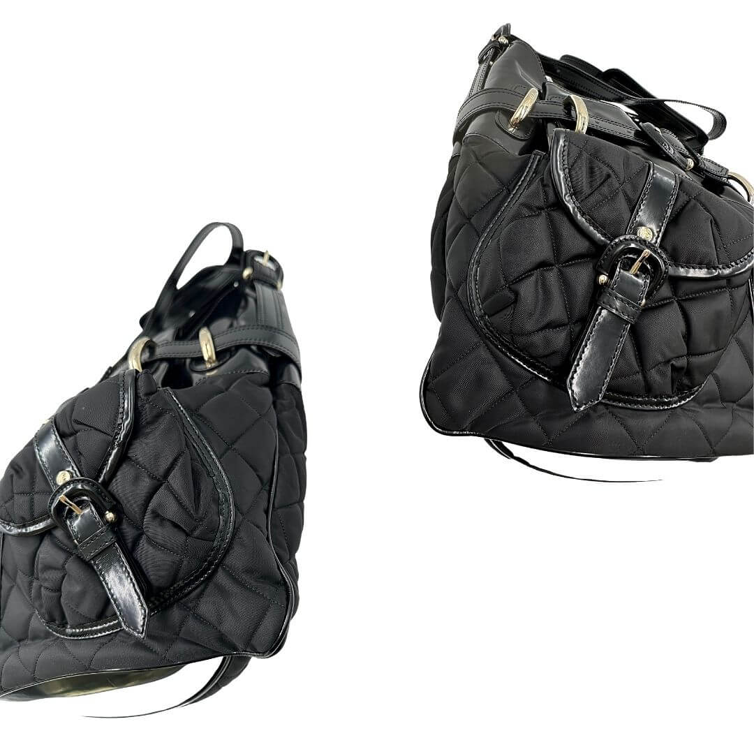 Shopper Burberry in tessuto trapuntato nero con finiture in pelle lucida tono su tono, arricchita da una fibbia decorativa. Munita di un manico singolo e una tracolla regolabile. Parti metalliche dorate. Originale, usato, condizioni ottime.