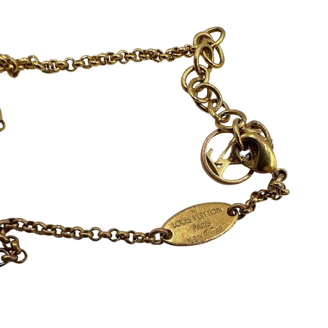 Bracciale LV Limited Edition in metallo dorato, con charm a forma di zucca e ciondolo logato LV a poi nero e bianco. Completo di corredo.