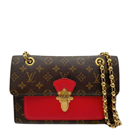 Borsa Louis Vuitton Victoire in canvas monogram con dettagli in pelle rossa e tracolla scorrevole in catena, rifinita con parti metalliche dorate. Originale, usato, in condizioni ottime.