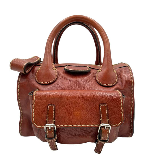 Bauletto Chloé in pelle martellata marrone bruciato con parti metalliche dorate e doppi manici stondati. Da portare a mano. Completo di dustbag. Originale, usato, in condizioni ottime.