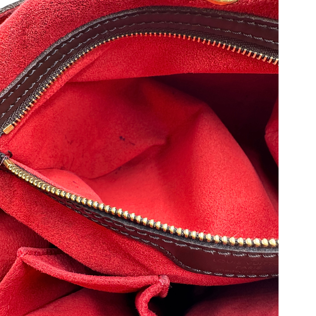 Interno di un taschino lievemente alonato di una borsa Hampstead Louis Vuitton in canvas marrone Damier Ebene con finiture in pelle testa di moro e parti metalliche dorate. Completa di dustbag.