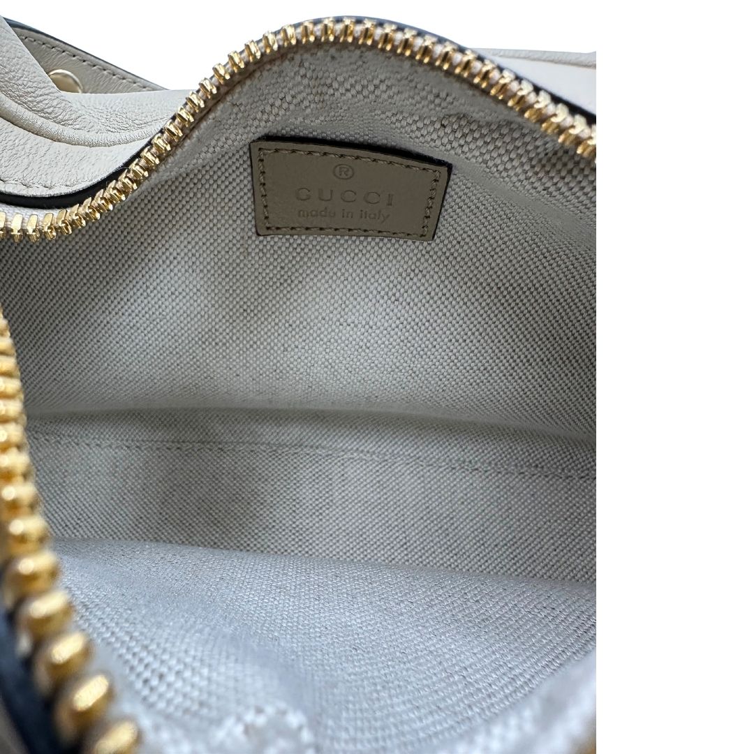 Borsa Gucci in pelle beige con dettagli decorativi metallici dorati e strisce Web lungo i bordi. Munita di un manico e una doppia tracolla di cui una in pelle e una in tessuto web, interni