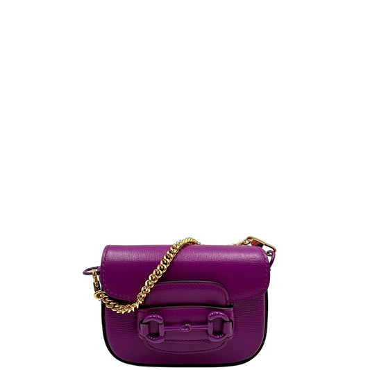 Mini Gucci Horsebit 1955 in pelle viola con catena in metallo dorato e tracolla in tessuto Web blu e rosso, con dettagli in pelle tono su tono. Rifinita con iconico morsetto Horsebit sul front. Completa di corredo. Originale, usato, condizioni eccellenti..