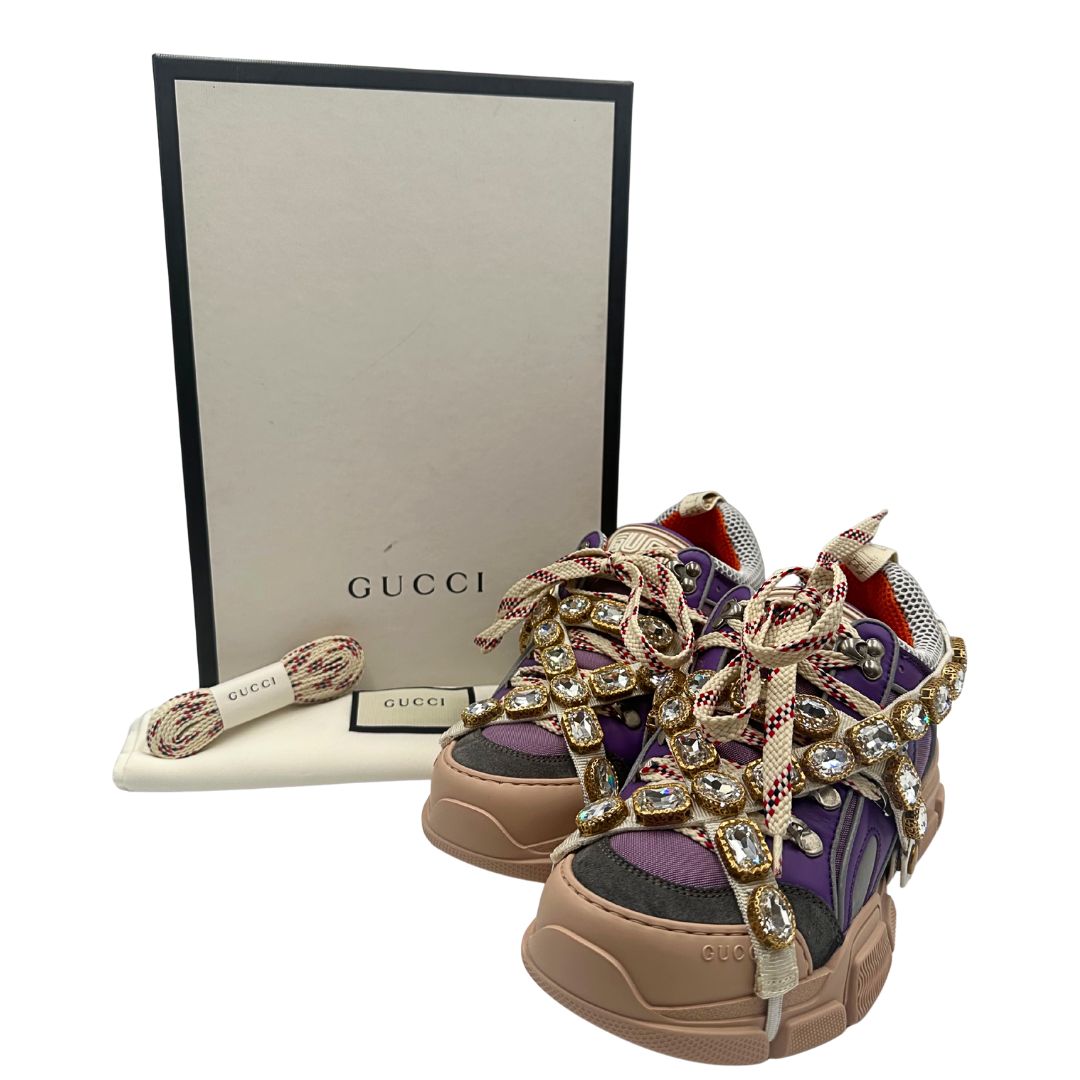 Sneakers Gucci Flashtrek Chunky con dettagli in pelle viola e tessuto scamosciato verde scuro. Suola chunky in gomma color nude, rifinite con iconica fascia decorativa rimovibile, e cristalli scintillanti. Chiusura con lacci. Complete di corredo. Originali, usato, condizioni eccellenti.