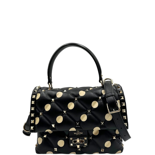 Borsa V.G. in pelle trapuntata nera impreziosita da pois e borchie su tutta la superficie, rifinita di inserti metallici dorati; munita di un manico e una tracolla regolabile e amovibile, indossata