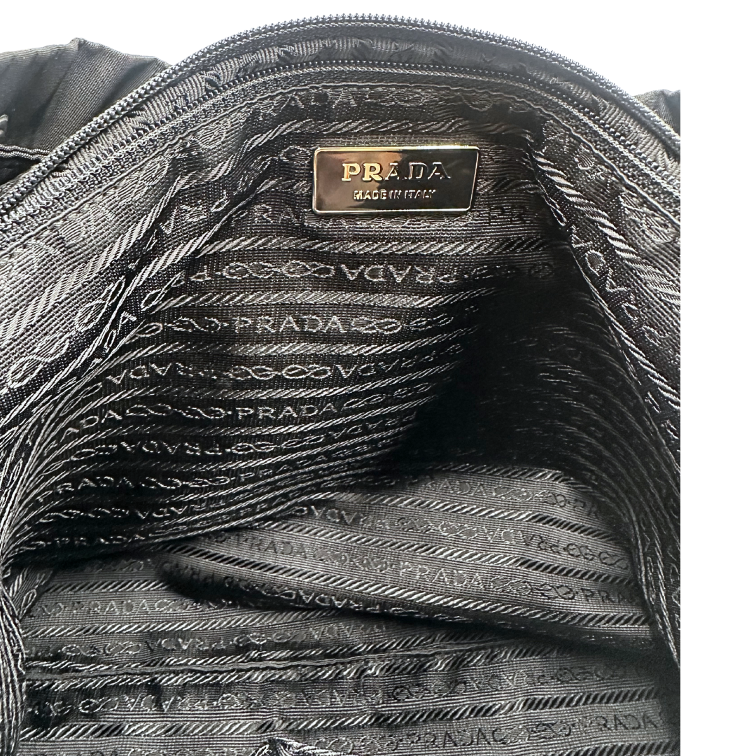 Zaino Prada in nylon nero rifinito con parti in pelle tono su tono e inserti metallici argentati, interno