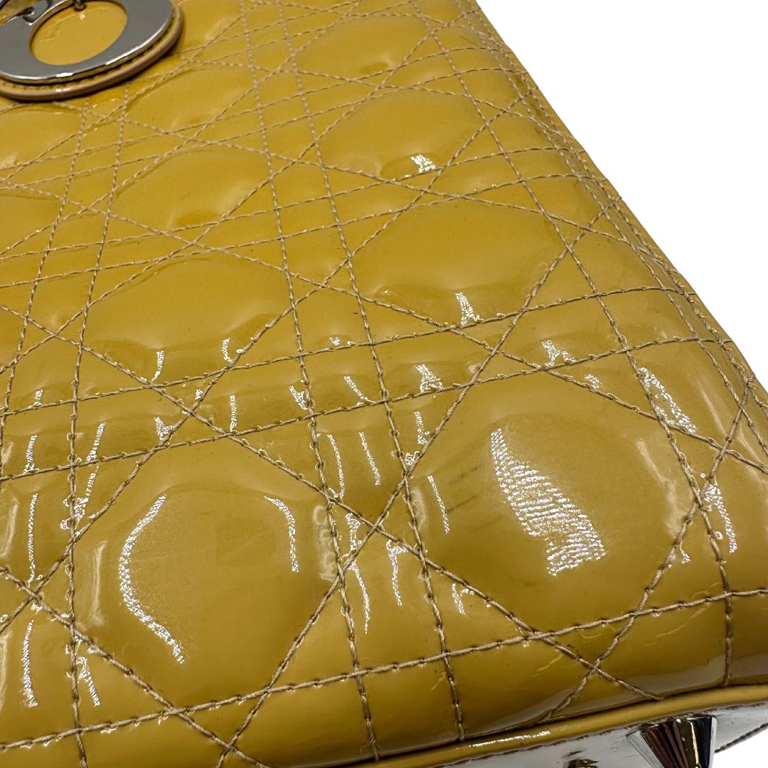 Dettaglio con lievi segni di utilizzo, Borsa Lady Dior in pelle verniciata giallo mostarda con doppi manici rigidi e una tracolla regolabile e amovibile. Rifinita con parti metalliche argentate. Completa di scatola e card d'autenticità. Originale, usato, condizioni ottime.