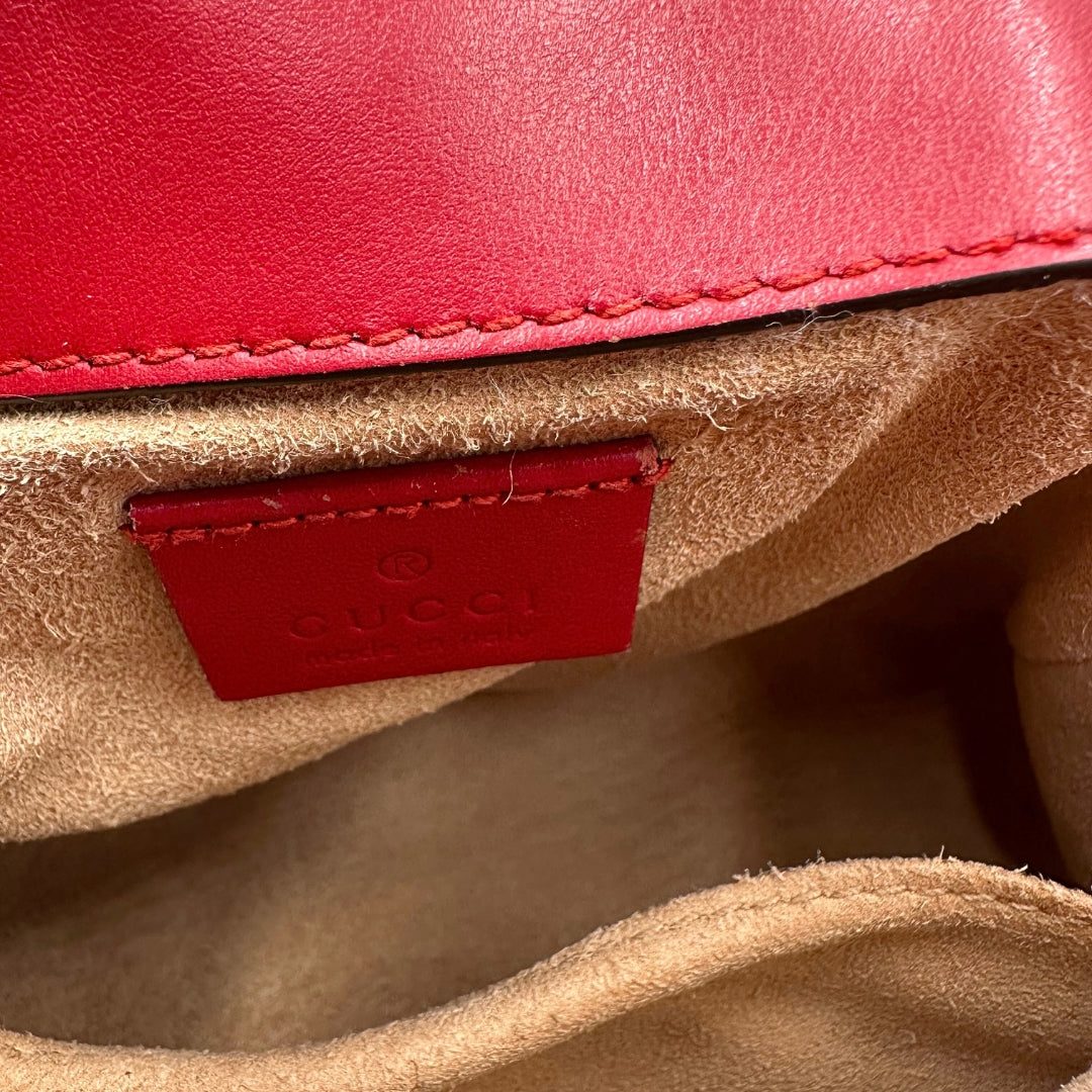 Borsa Gucci Marmont in pelle matelassé rossa con tracolla scorrevole in catena e spallaccio in pelle e un manico singolo, rifinita con parti metalliche dorate, interno