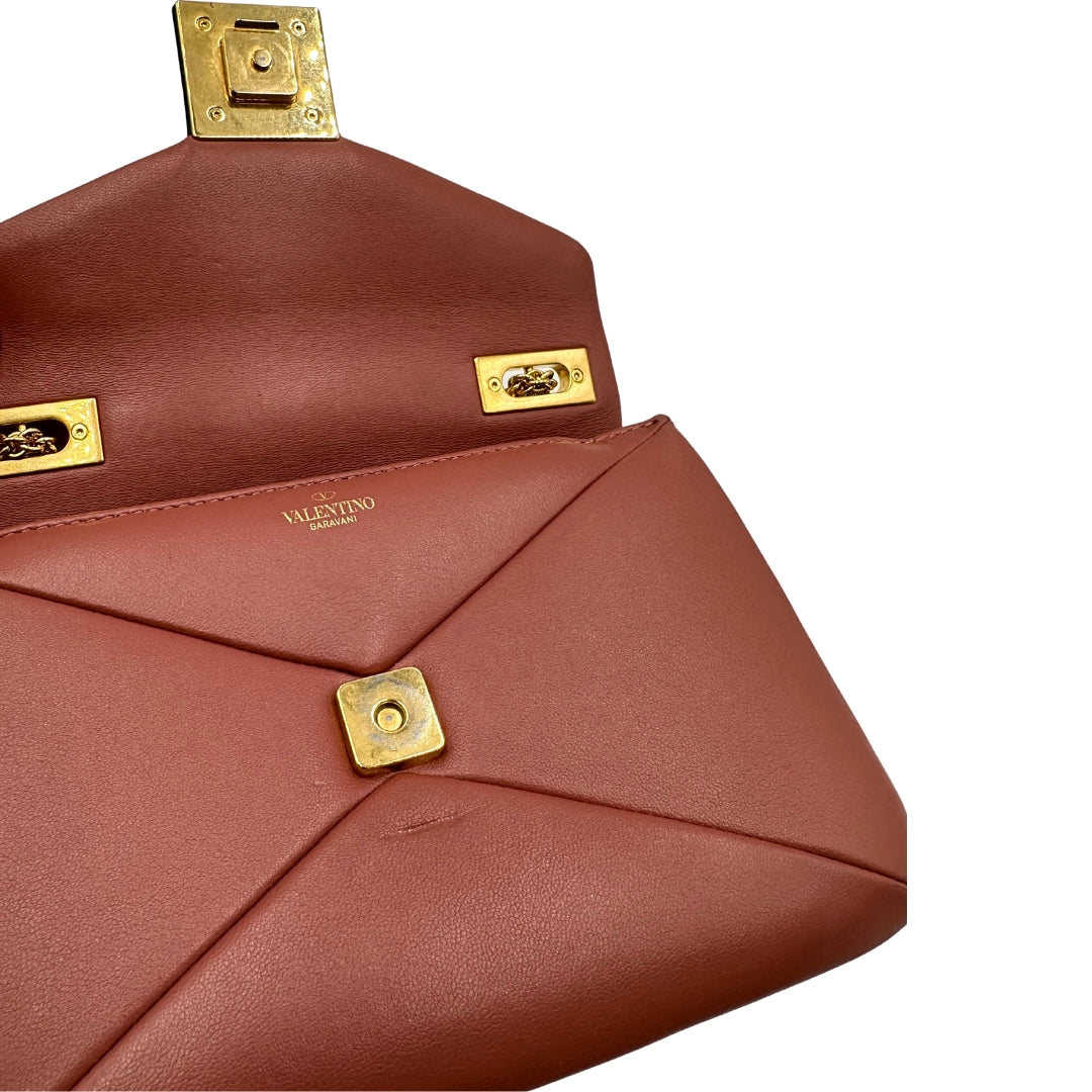 Borsa One Stud Valentino Garavani in pelle color marsala con tracolla in catena scorrevole e iconica chiusura con maxi borchia piramidale. Completa di corredo. Originale, usato, in condizioni ottime.