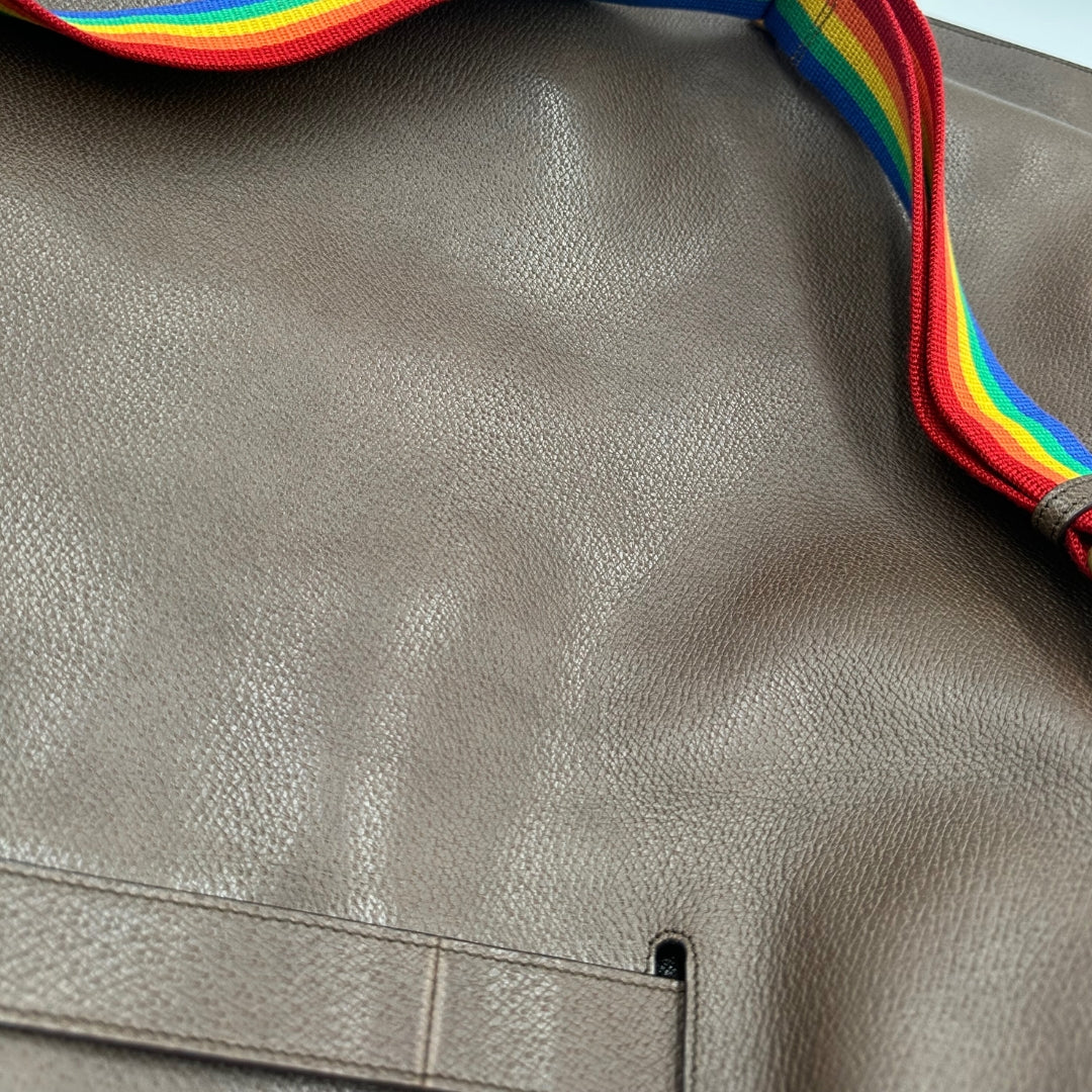 Borsone Gucci in pelle martellata marrone con tracolla regolabile in tessuto Rainbow e doppi manici in bamboo. Rifinito con parti metalliche dorate. Completa di dustbag. Originale, usato, in condizioni ottime.