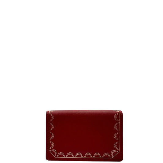 front Portafoglio Cartier in pelle bordeaux rifinito con motivi decorativi dorati.