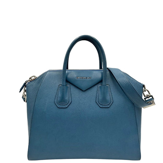Borsa Givenchy Antigona in pelle martellata blu petrolio munita di doppi manici stondati e tracolla. Parti metalliche argentate. Completa di dustbag. Originale, usato, in condizioni ottime.