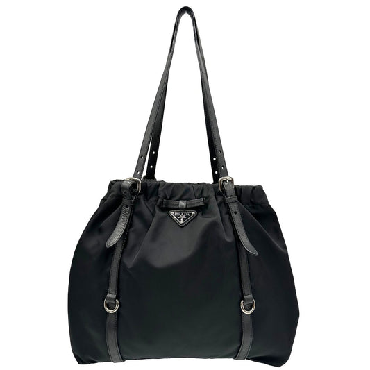 Front di una borsa Prada in nylon e finiture in pelle nere. Parti metalliche argentate; munita di doppi manici regolabili. Completa di dustbag e card d'autenticità.