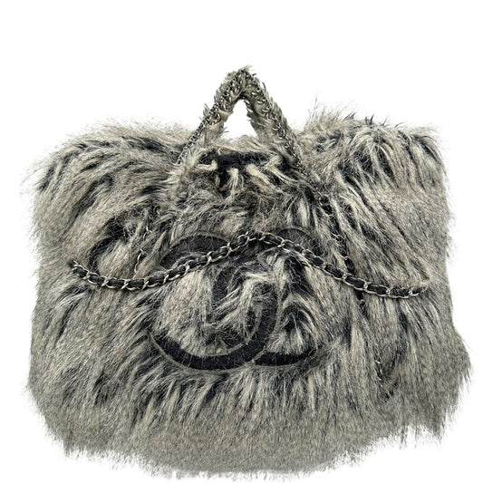 Borsa Chanel Grey Arctic in pelliccia sintetica sui toni del grigio e nero sfumato con parti metalliche argentate. Impreziosita da catene con pelle intrecciata e rifinita con logo CC sul front. Munita di doppi manici in catena e pelliccia. Completa di dustbag. Originale, usato, in condizioni ottime.