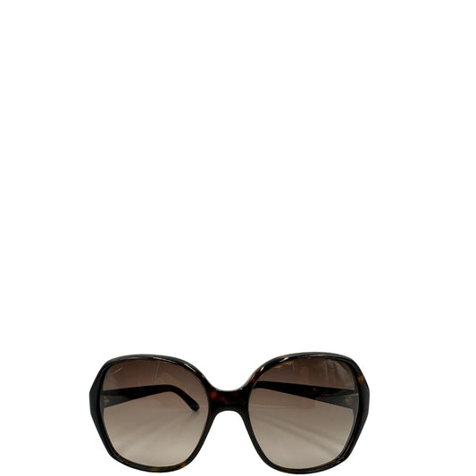 Front di un paio di occhiali da sole Gucci in acetato marrone tartarugato, rifiniti con aste nere con dettagli doppie G Web, lenti sfumate tono su tono. Completi di custodia.