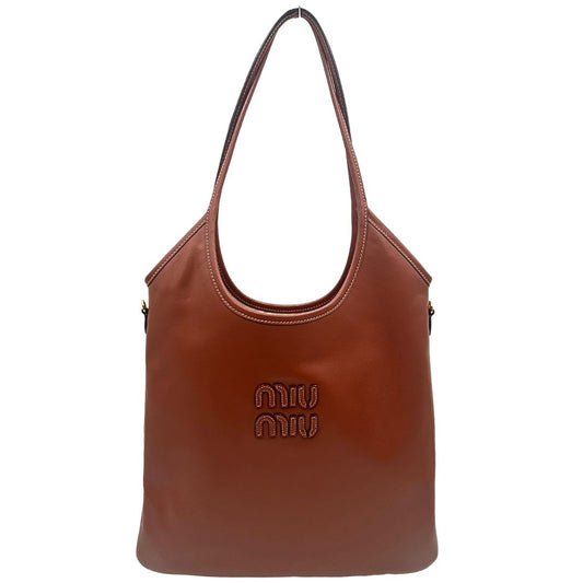 FRONT Borsa Miu Miu in pelle color cognac con parti metalliche dorate; munita di doppi manici, indossabile a spalla. Completa di busta logata e dustbag, di lusso, originale, ottime condizioni.