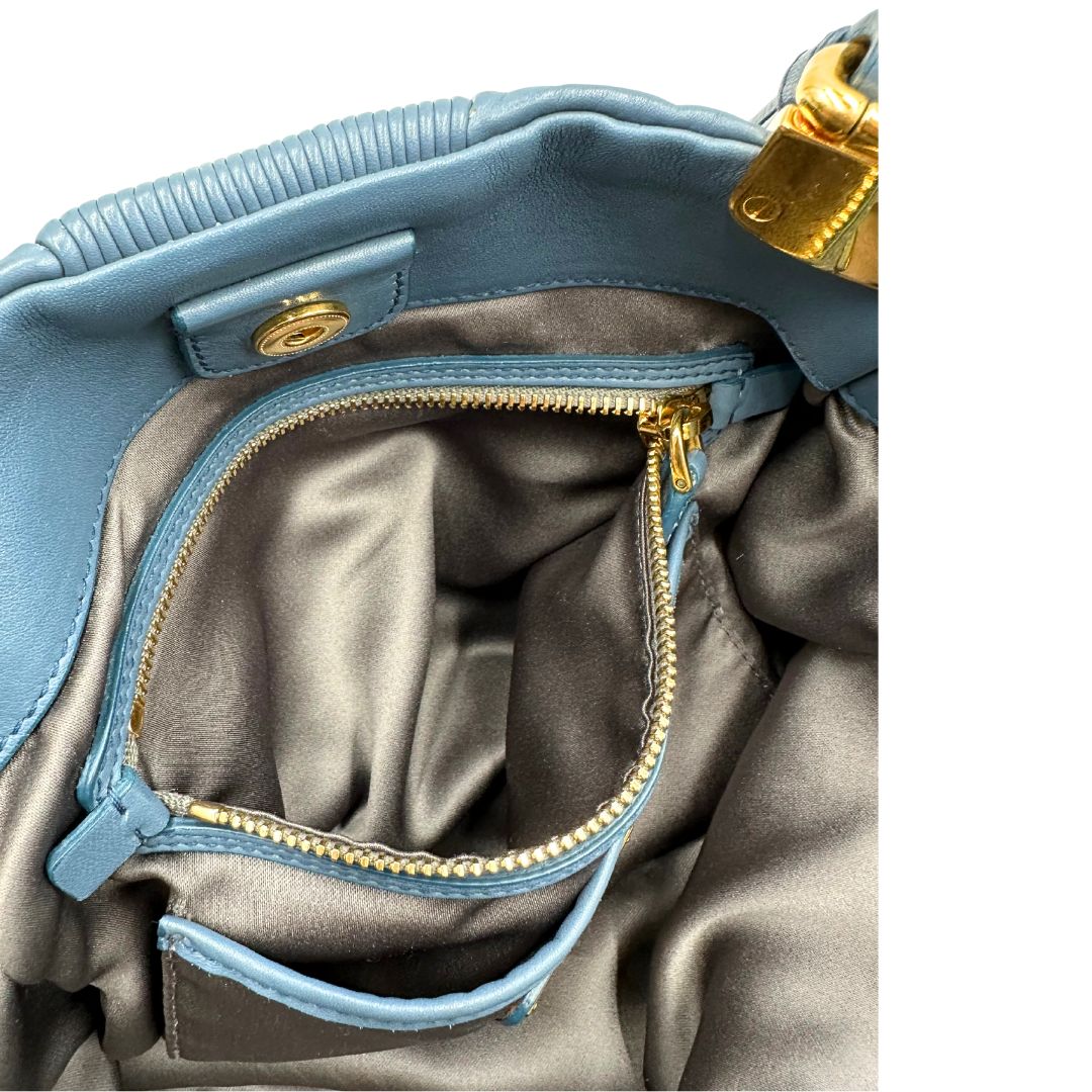 interno Borsa Miu Miu in pelle blu con parti metalliche dorate; munita di doppi manici, indossabile a spalla. Completa di dustbag, di lusso, originale, ottime condizioni.