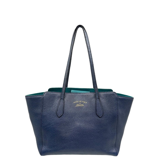Front di una borsa Gucci in pelle martellata blu scuro, rifinita con inserti metallici dorati; dotata di doppi manici. Indossabile a spalla. Munita di dustbag.