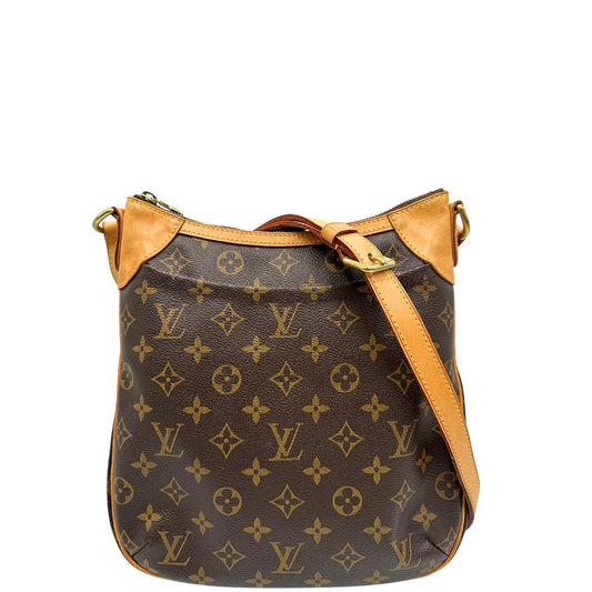Front di una borsa Odeon PM Louis Vuitton in canvas marrone monogram con finiture in vacchetta naturale e parti metalliche dorate. Dotata di tracolla regolabile con fibbia. Munita di dustbag.