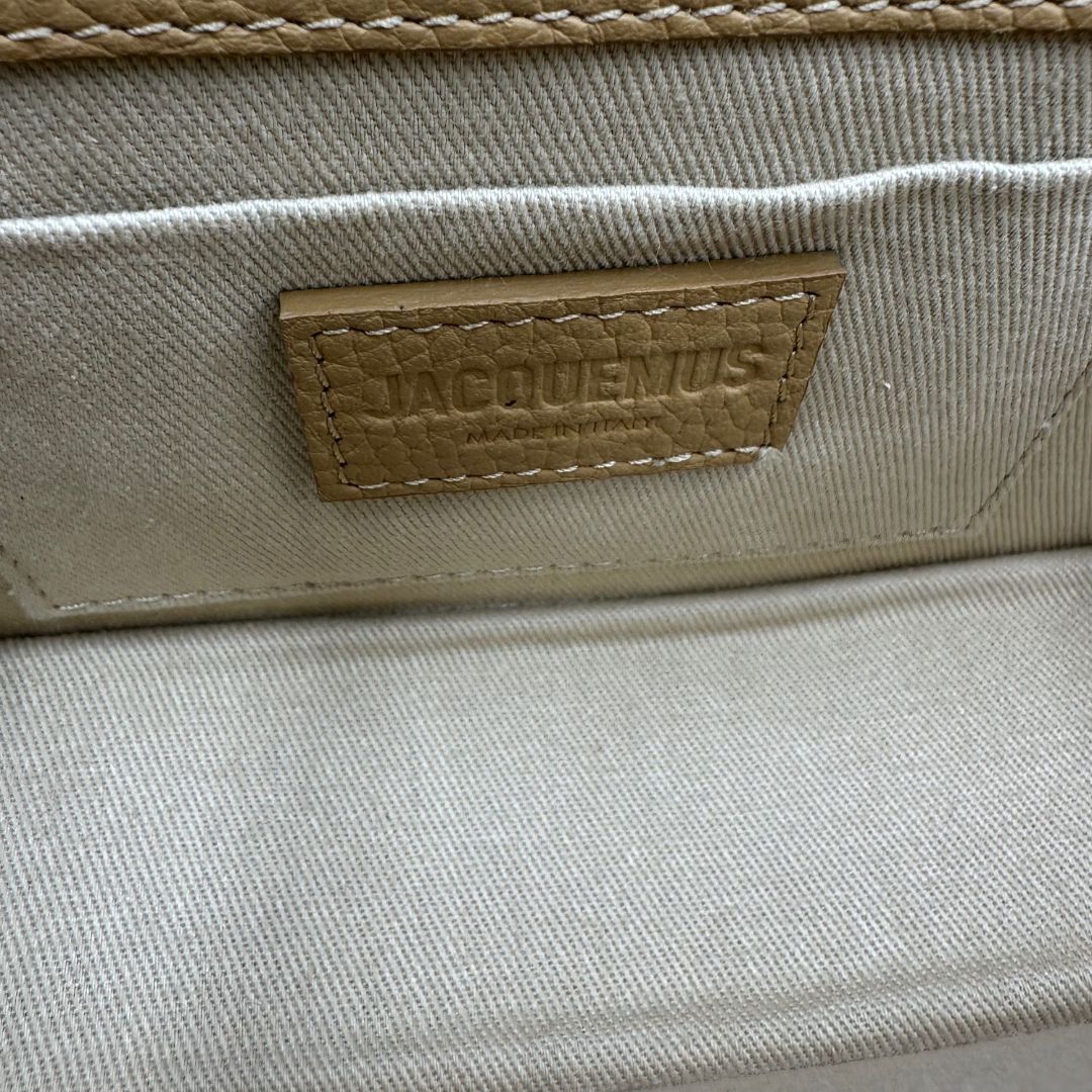 interno Borsa Jacquemus in pelle martellata color cammello con parti metalliche dorate; munita di un manico singolo e una tracolla amovibile e regolabile. Completa di dustbag, di lusso, originale, ottime condizioni, usata.