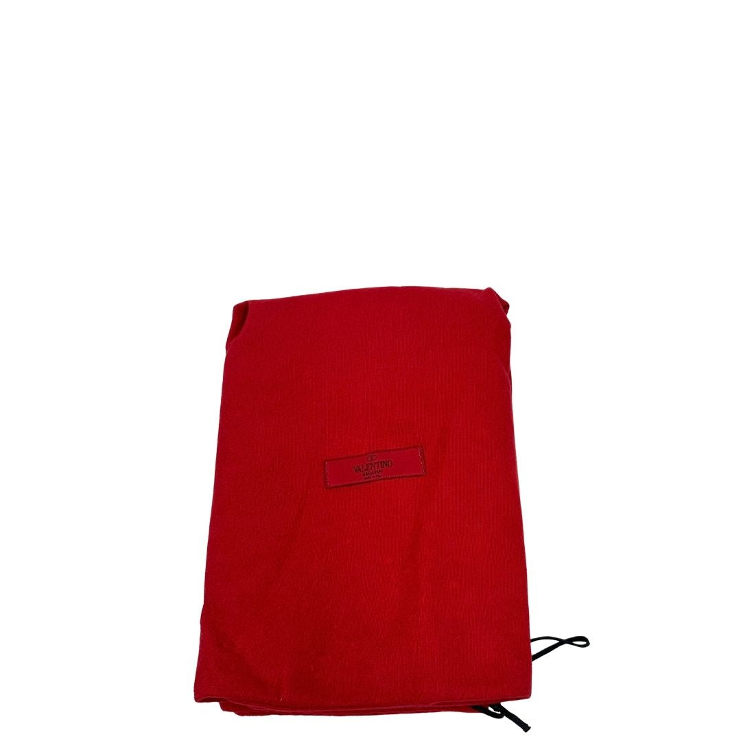 Dustbag di una borsa Valentino Garavani in pelle rossa con parti metalliche dorate; impreziosita da borchie piramidali e munita di doppi manici e tracolla amovibile.