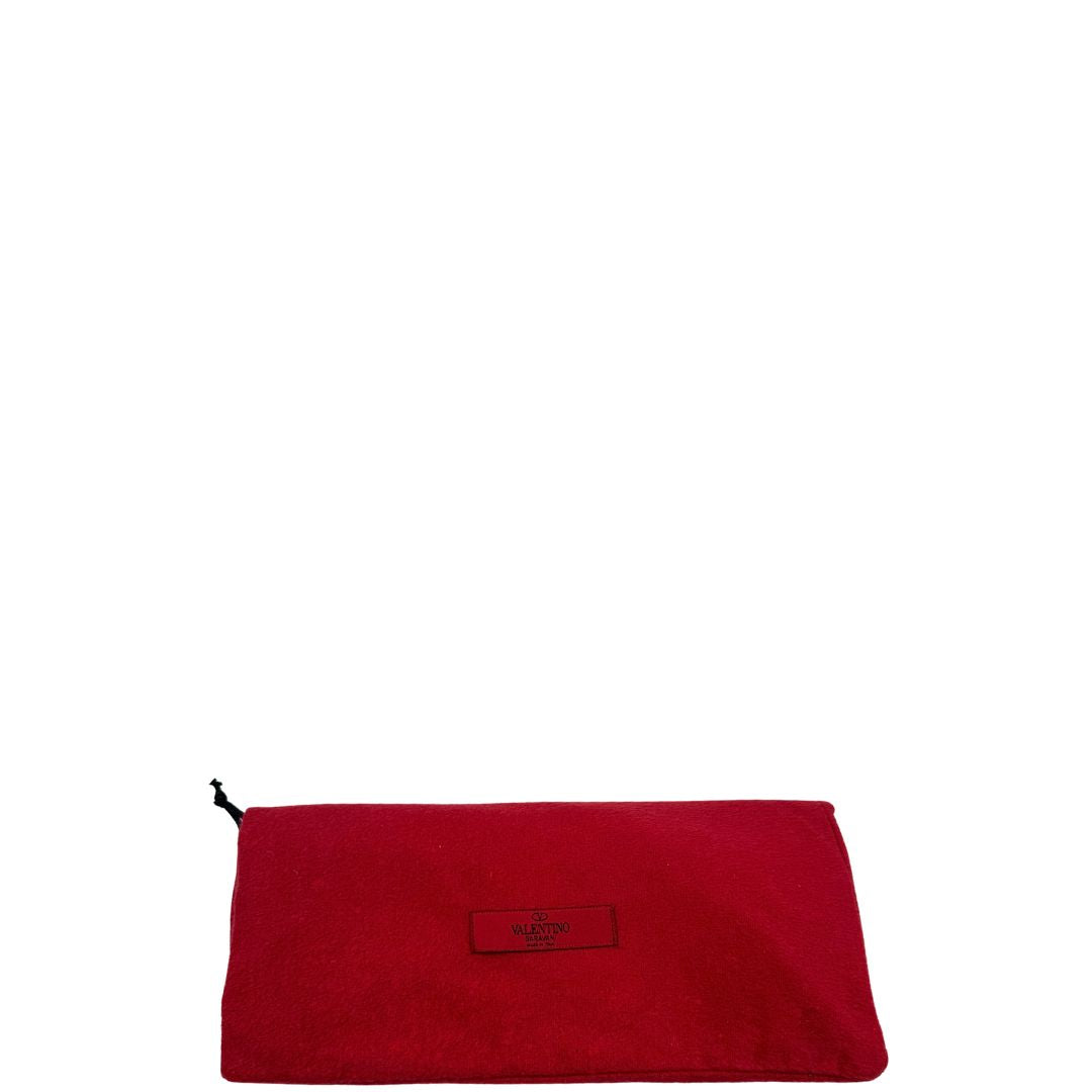 Sacchetto anti polvere di un paio di stivaletti VG in pelle rossa con tacco basso e dettagli borchie oro chiaro.