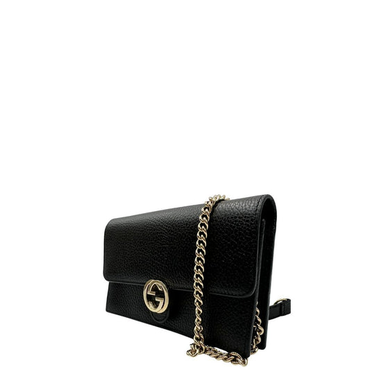 Laterale destro di una borsa Gucci Interlocking in pelle martellata nera con parti metalliche oro chiaro. Munita di una tracolla amovibile in catena e spallaccio in pelle. Chiusura con doppie G incrociate. Completa di scatola e dustbag. Indossabile a tracolla.