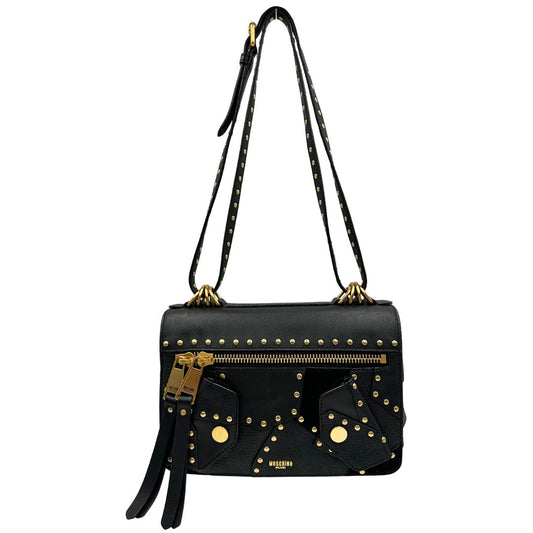 Front di una Borsa Moschino in pelle nera con inserti metallici dorati, arricchita da borchie dorate, zip frontale con maxi tirazip e applicazioni geometriche. munita di una tracolla regolabile non amovibile. Completa di Card d'autenticità Misure. Originale, Usata, di lusso, in ottime condizioni.