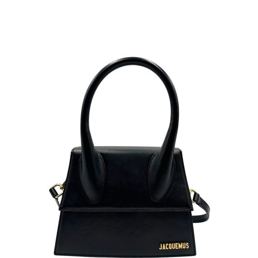 Front di una Borsa Le Grand Chiquito Jacquemus in pelle nera con parti metalliche dorate, munita di un manico stondato e una tracolla amovibile e regolabile. Completa di dustbag e cartellino. Originale, usata, di lusso, in ottime condizioni.