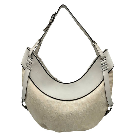Front di una borsa Gucci in tessuto avorio GG con parti in pelle bianco gesso e parti metalliche argentate. Indossabile a spalla.