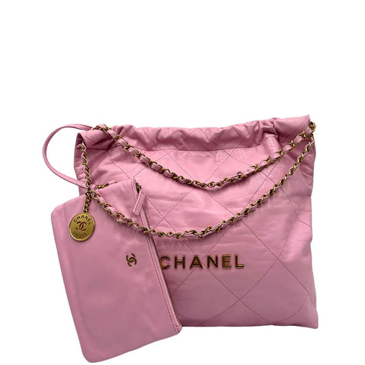 Front di una borsa Chanel 22 in pelle trapuntata rosa con parti metalliche dorate; dotata di pochette estraibile e amovibile, doppi manici in catena e pelle per portarla a spalla. Chiusura con bottone automatici. Completa di scatola e dustbag.