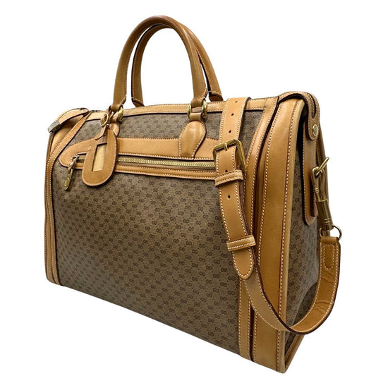 Laterale destro di una borsa Gucci in canvas beige GG con finiture in pelle color cammello e parti metalliche dorate, munita di doppi manici stondati e di una tracolla amovibile e regolabile. Dotata di tag porta address.