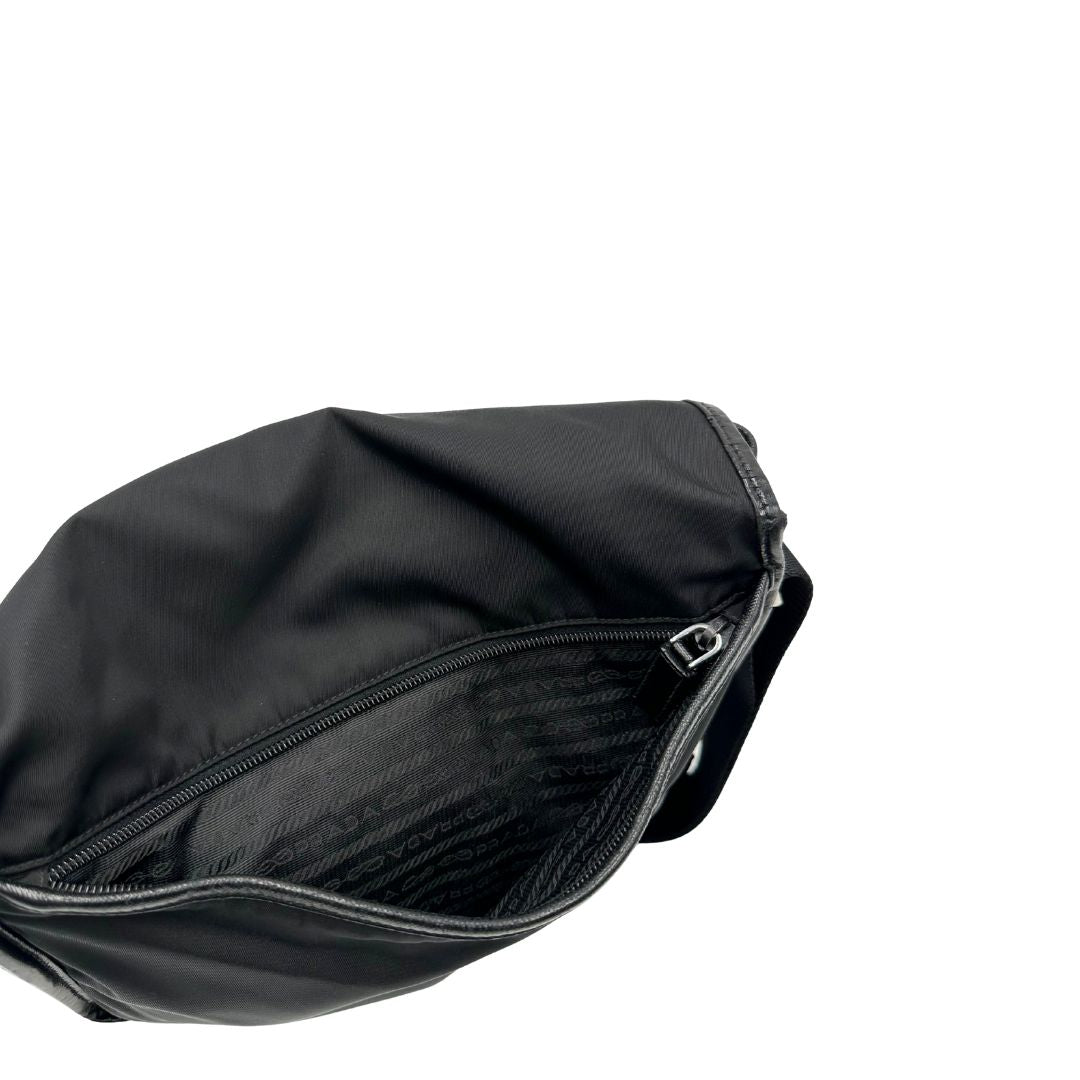 Tasca esterna di una Borsa Prada in nylon nero con finiture in pelle tono su tono e parti metalliche argentate; munita di una tracolla regolabile in tessuto. Originale, usata, di lusso, in ottime condizioni.