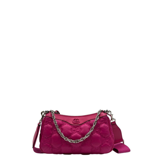 Front di una borsa Gucci in nylon trapuntato matelassé fucsia con trama GG, finiture in pelle tono su tono, manico singolo in catena e tracolla in tessuto regolabile ed amovibile. Rifinita con parti metalliche argentate. Completa di dustbag.
