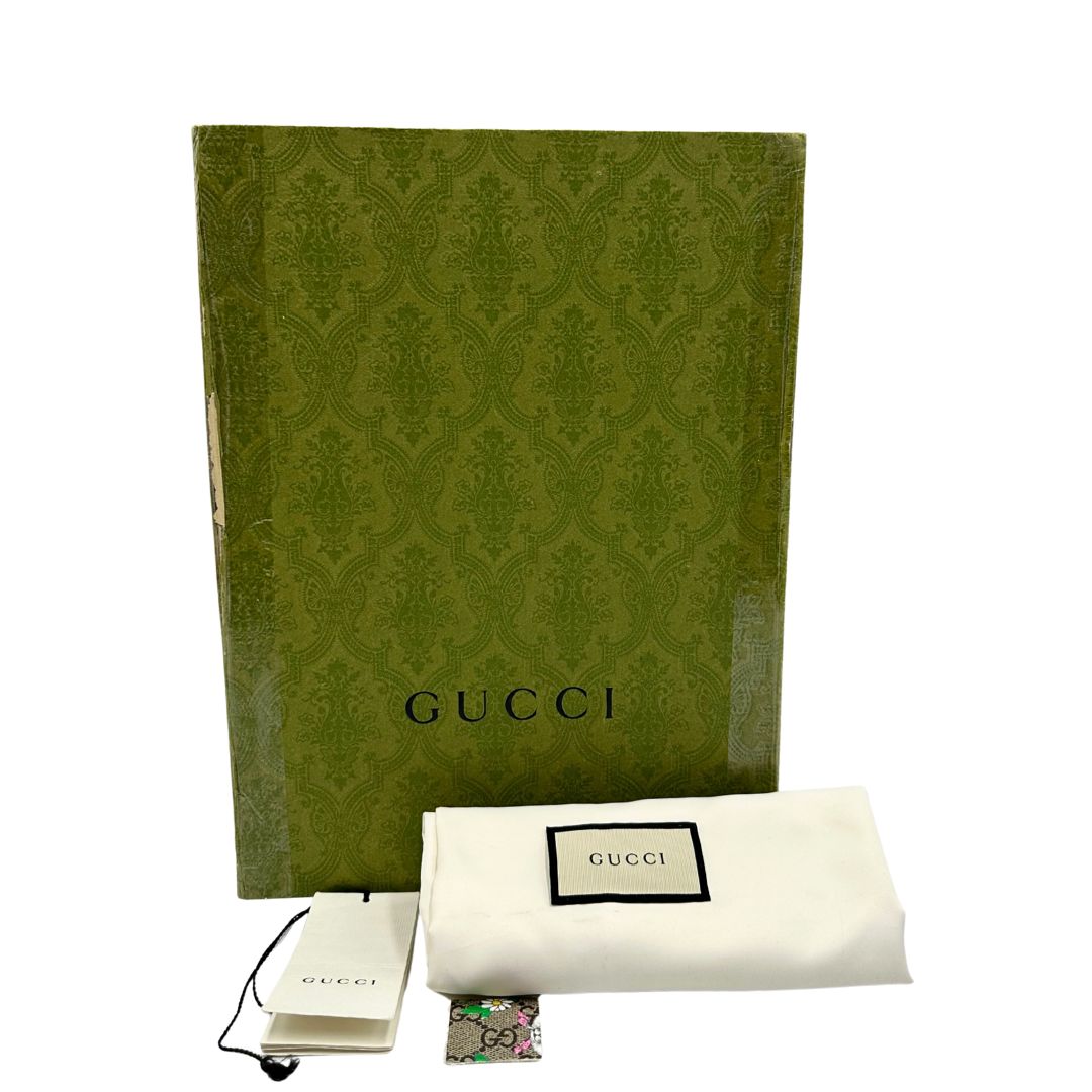 Corredo di uno zaino Gucci Kids in canvas monogram GG beige con stampa floreale e animaletti; finiture e interno in pelle gialla. Chiusura a patta con doppi ganci e parti metalliche argentate; dotato di manico superiore e doppie bretelle regolabili in tessuto verde oliva con ricami a farfalle fucsia.