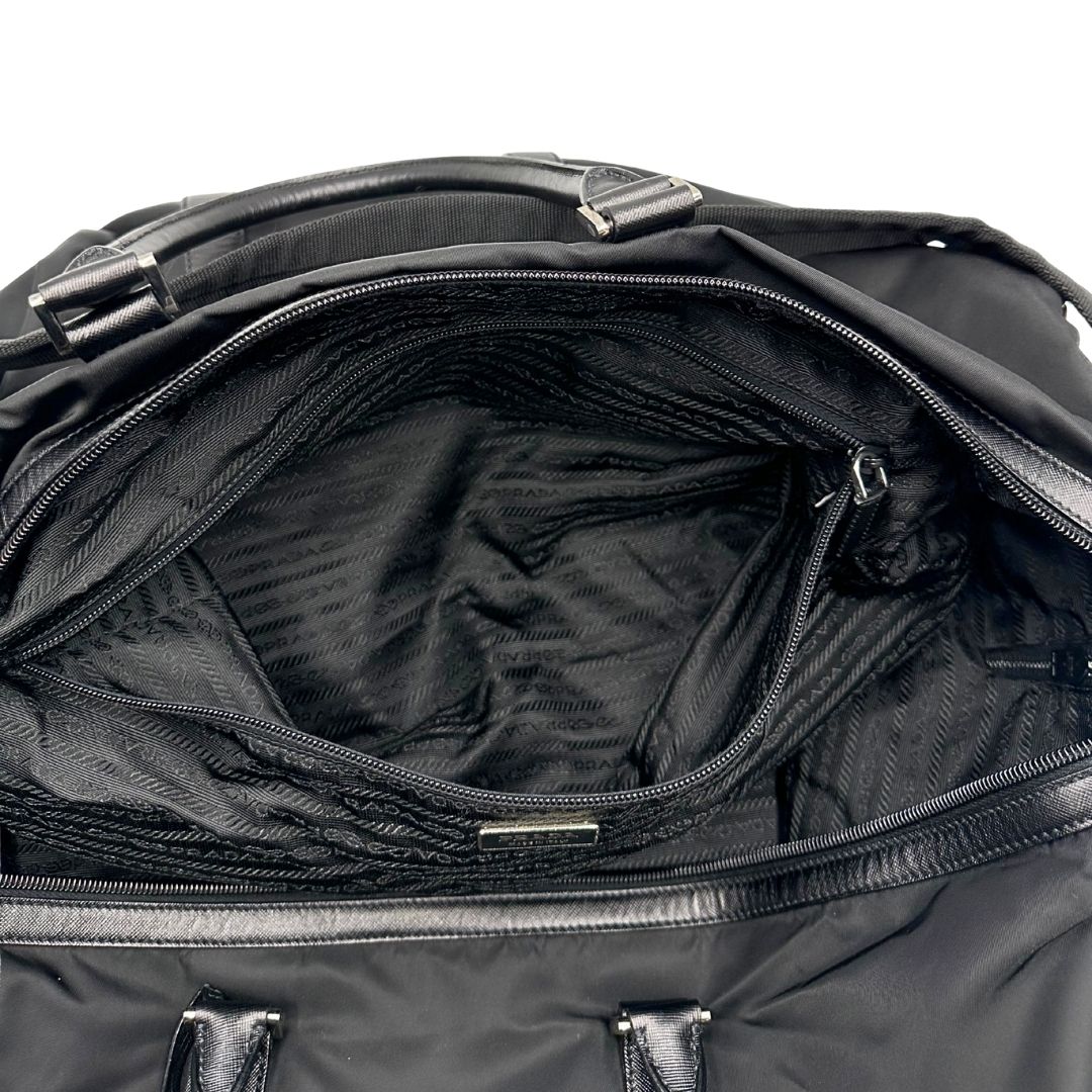 interno Borsone Prada in nylon nero con finiture in pelle tono su tono e parti metalliche argentate; munito di doppi manici stondati e un manico singolo in tessuto, indossabile a spalla o mano. Completo di dustbag e tag porta address, di lusso, originale, ottime condizioni, usata.