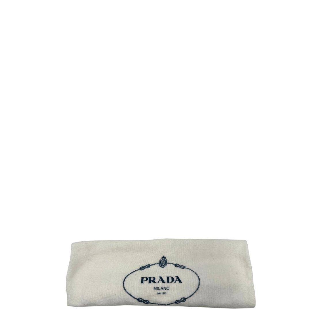 Dustbag di una borsa Prada Re-Edition 2005 in nylon nero con dettagli in pelle e hardware argento, arricchita da catena frontale, mini pouch removibile e portachiavi logato. Modello compatto e versatile, utilizzabile a spalla, a mano o crossbody, usata, originale, second hand, in condizioni eccellenti.