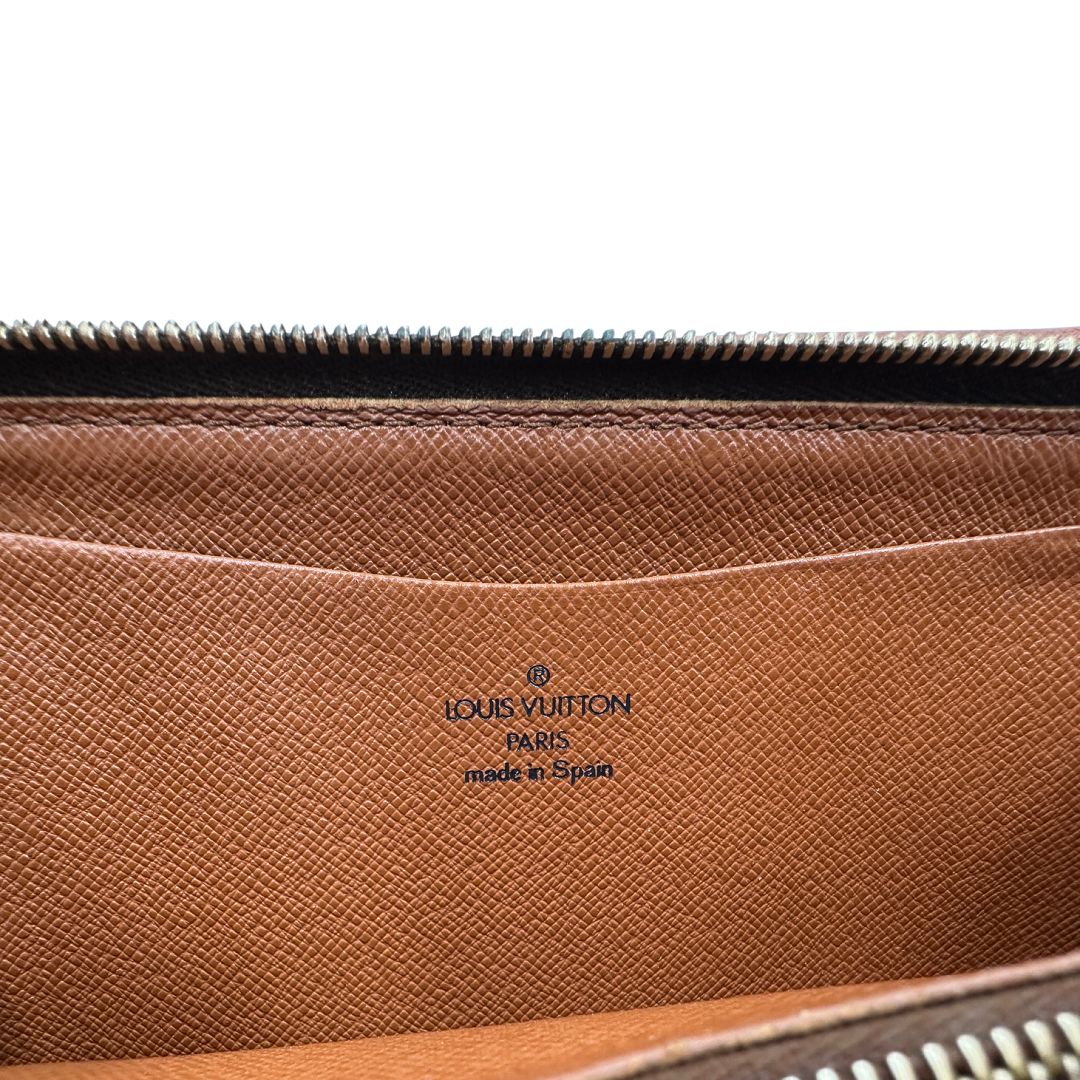 Logo Portafoglio compatto Louis Vuitton in canvas marrone monogram, con chiusura con cerniera e parti metalliche dorate. Originale, di lusso, usato, in condizioni ottime.