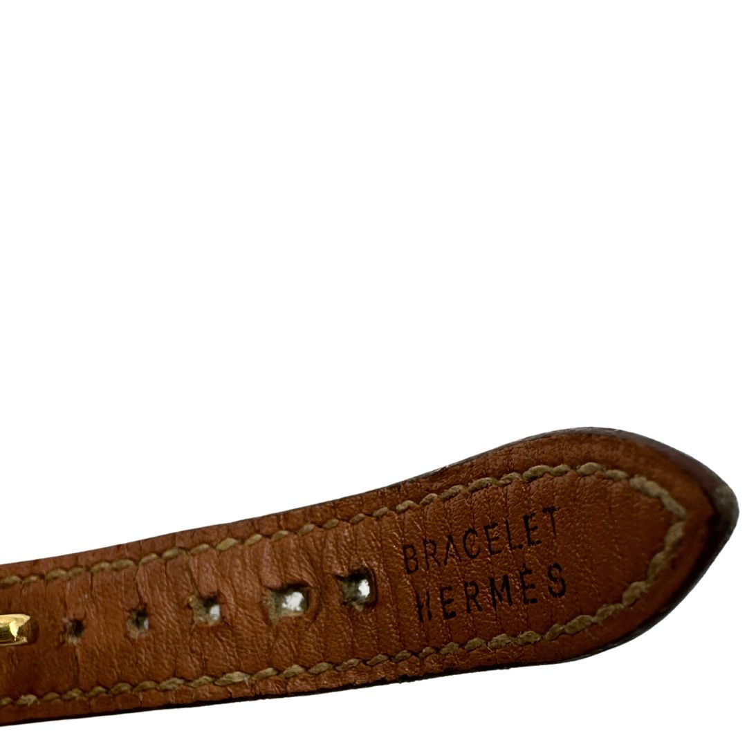 Elegante Hermès Année de la Fantaisie "Vive l'Idée!", bracciale in pelle marrone con finiture dorate e un caratteristico lucchetto a forma di cuore.