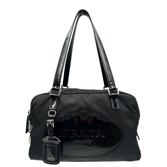 front Borsa Prada in nylon nero con finiture in pelle tono su tono e parti metalliche argentate; munita di doppi manici e accessorio porta address, di lusso, originale, ottime condizioni, usata.