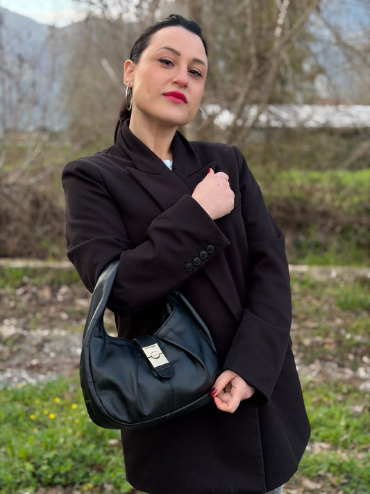 Ragazza che indossa una borsa modello hobo Borbonese in morbida pelle nera, con metalleria dorata, usata, originale, second hand, in ottime condizioni.