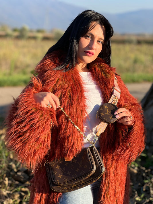 Ragazza che indossa una Multi Pochette Accessoires Louis Vuitton in canvas marrone monogram con dettagli in vacchetta naturale, manico in catena dorata e tracolla in tessuto Jacquard rosa. Dotata del classico mini portamonete rotondo, rimovibile. Munita di scatola.