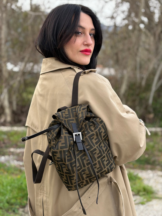 Ragazza che indossa uno zaino Fendi in trama Zucca, nelle tonalità del marrone e tabacco, usato, originale, second hand, in ottime condizioni.