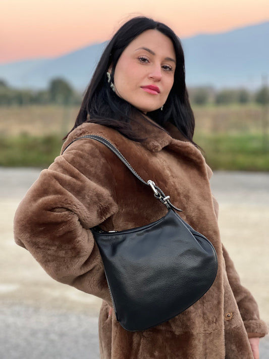 Ragazza che indossa una borsa Fendi in pelle nera con parti metalliche argentate. Indossabile a spalla. Munita di dustbag.