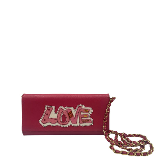 Pochette Prada in pelle saffiano rosa peonia rifinita con parti metalliche dorate e munita di una tracolla in catena e pelle intrecciata, front