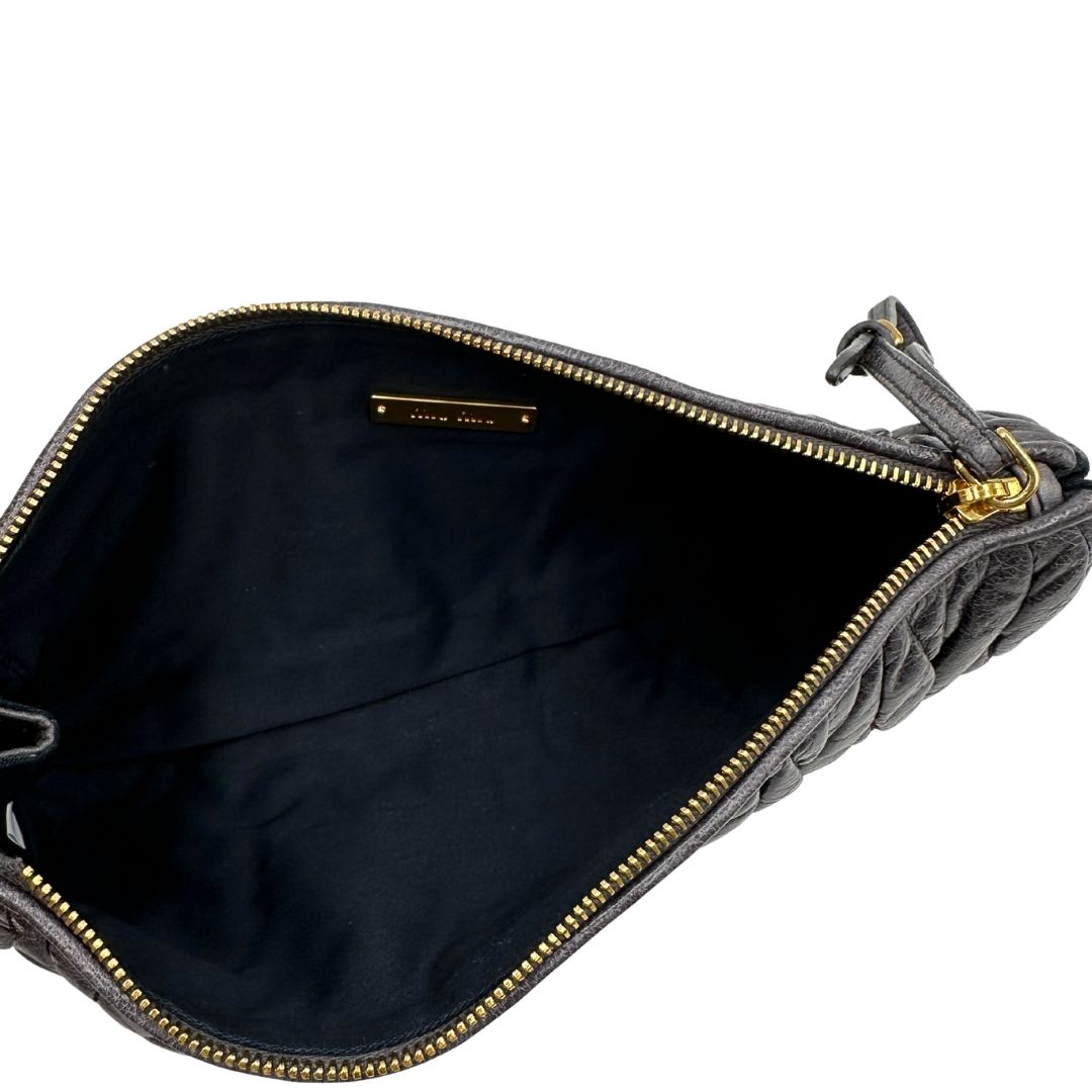 interno Pochette Miu Miu in pelle matelassè grigia effetto invecchiato con parti metalliche dorate; munita di un polsino, da portare a mano, di lusso, originale, ottime condizioni.