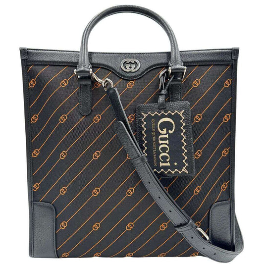 Sac Plat Gucci in tessuto Jacquard nero con trama GG incrociate arancione e finiture in pelle tono su tono. Parti metalliche argentate, e munita di doppi manici stondati e una tracolla regolabile, e amovibile.